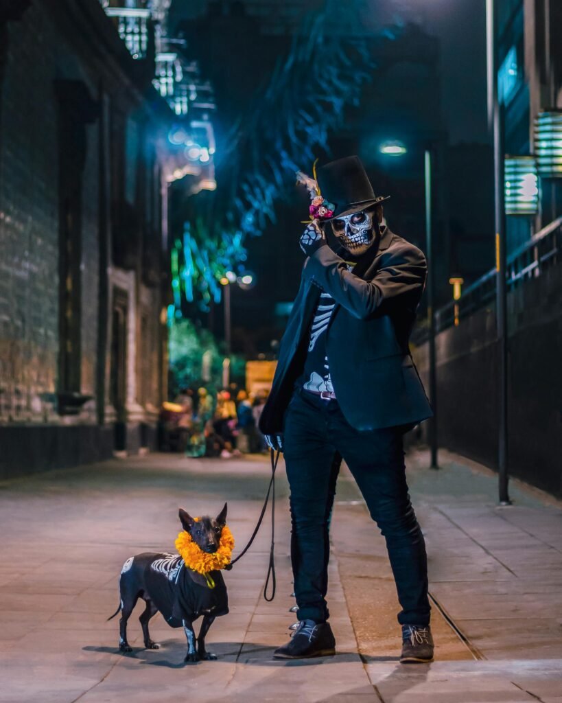 Man and dog dressed in Day of the Dead costumes on a vibrant street in Mexico City.